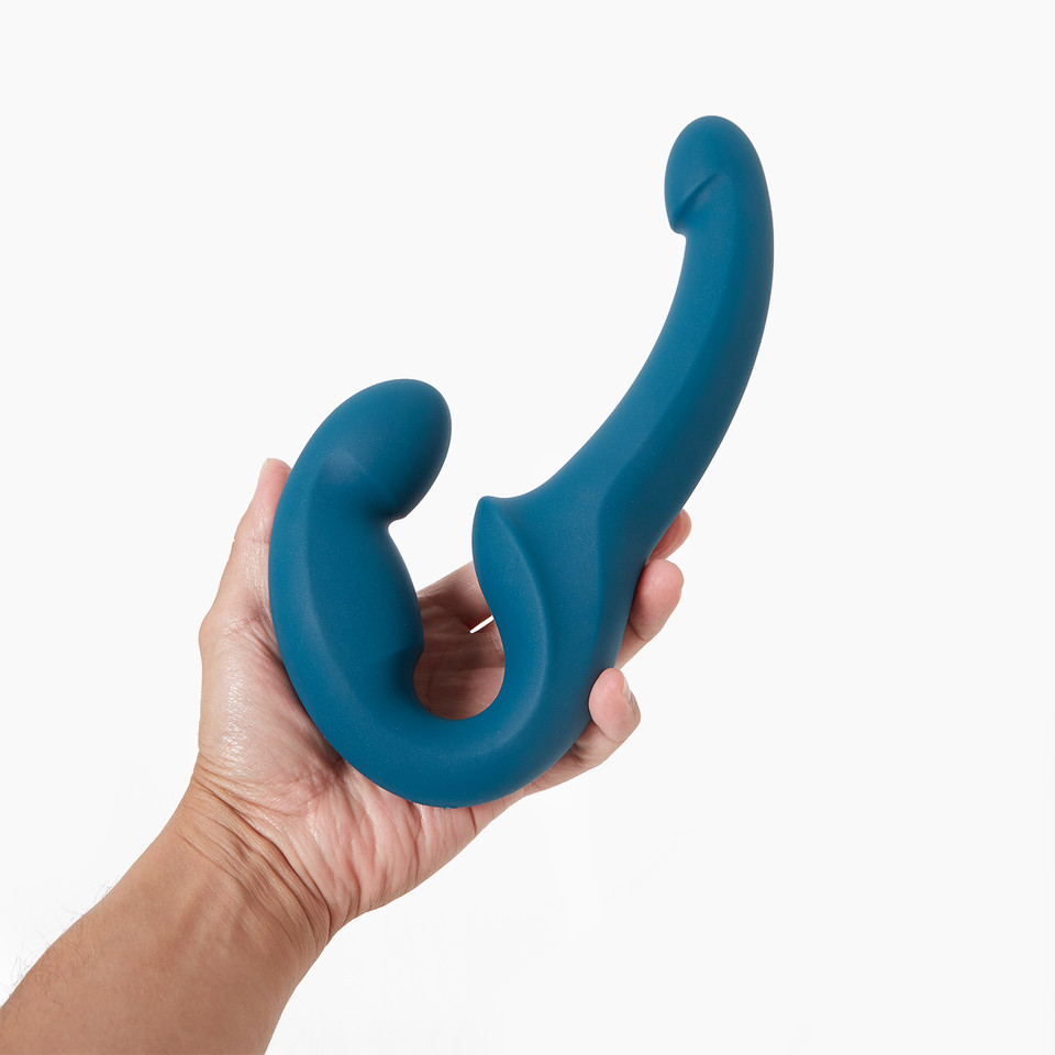 Hand holding a teal Fun Factory Share Lite double-ended dildo