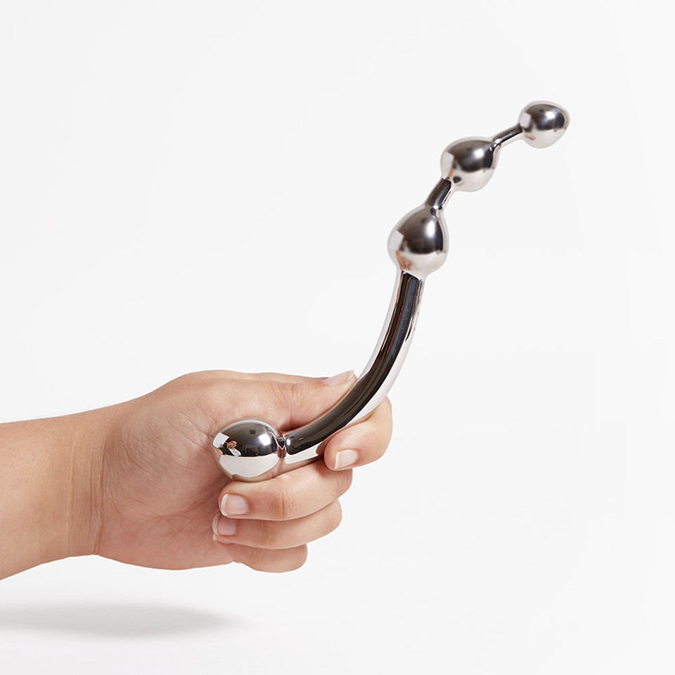 Hand holding a curved, stainless steel Njoy Fun Wand with bulbous ends