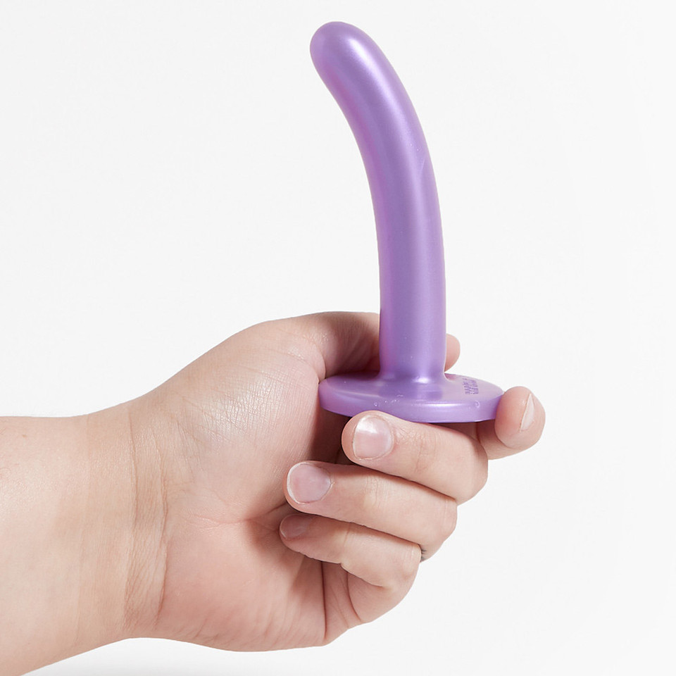 Hand presenting the Tantus Silk, a small purple silicone dildo